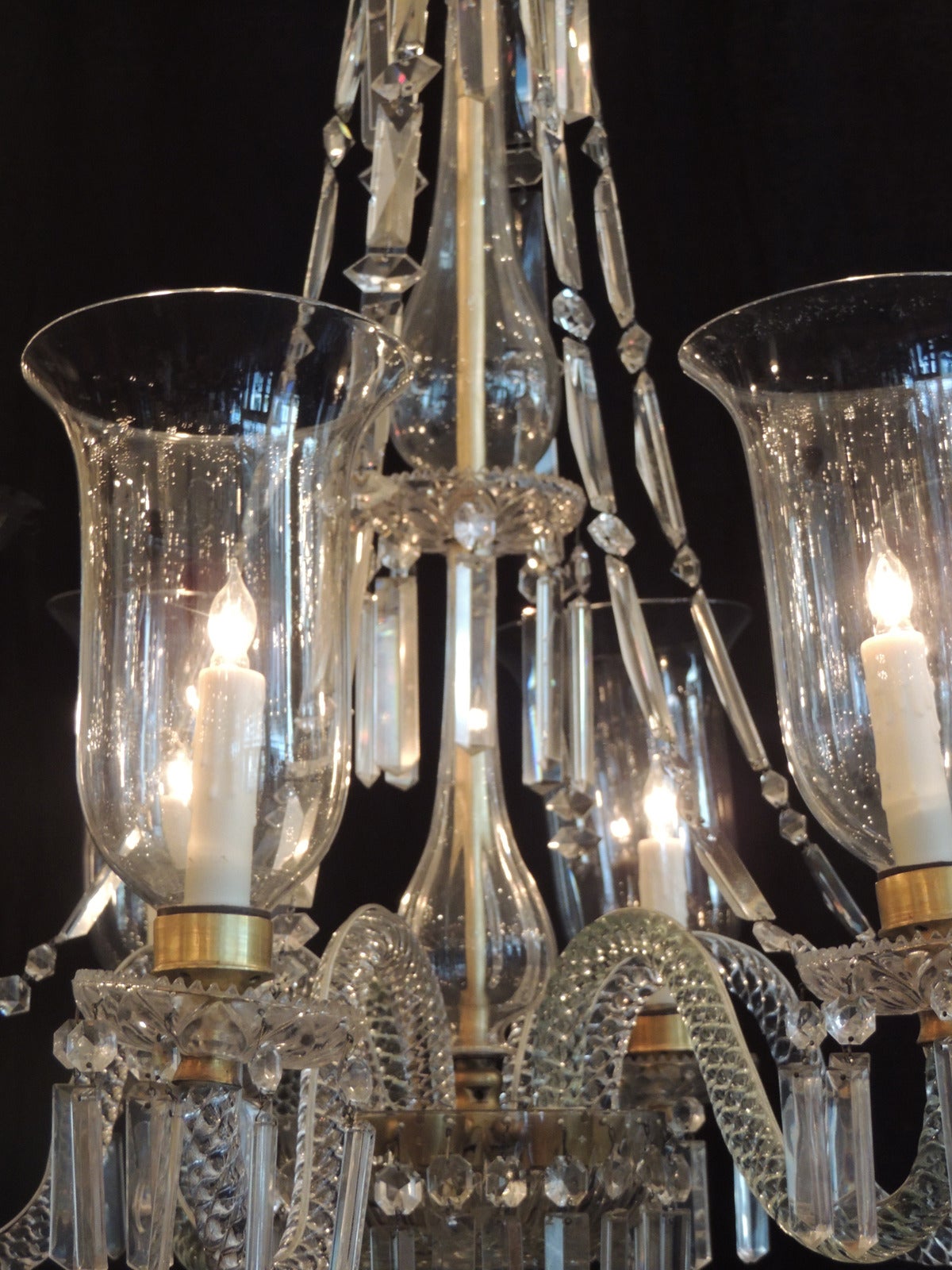 This grand Georgian crystal chandelier was made in the Ireland, circa 1770. This fixture features six lights with cut crystal bobeches, original hurricane shades and cut crystal arms. The middle structure of the piece is covered with a crystal