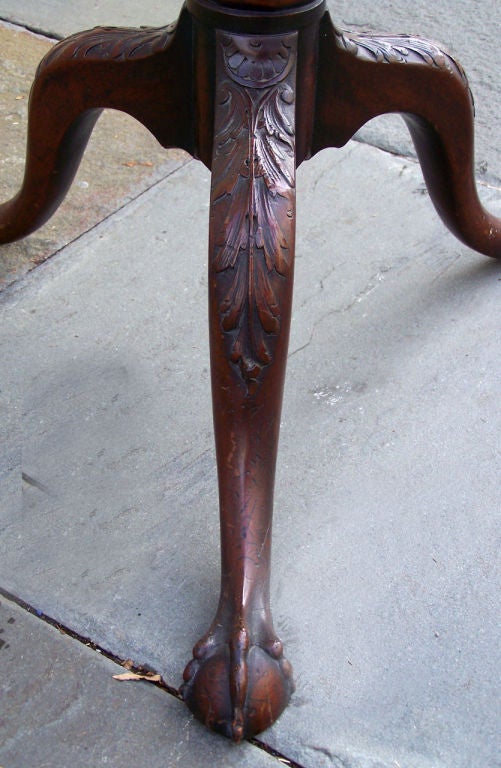 American tilt top table with twist classical urn barrel. Nicely executed acanthus and foliate carving down the leg and knee. Single board crotch mahogany top with scrolled ears makes for a beautiful presentation. Unusual