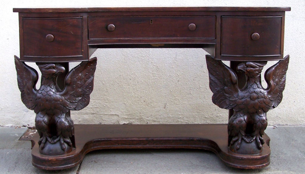 Mahogany desk/console with ornately carved double eagles. Fantastic carving on fully figured eagles facing each other and mounted on rounded globes. Potthast labels on the underside. Potthast sold both original and period pieces. This is a most