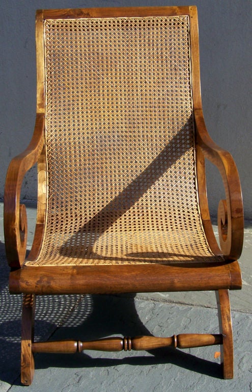 Curule planters chair, hand caned, design usually found in the Spanish islands. Plantation chair has robust rolled arms, and a comfortable reclined back.

French West Indies, Colonial, Island, Antilles, Lesser Antilles, Caribbean