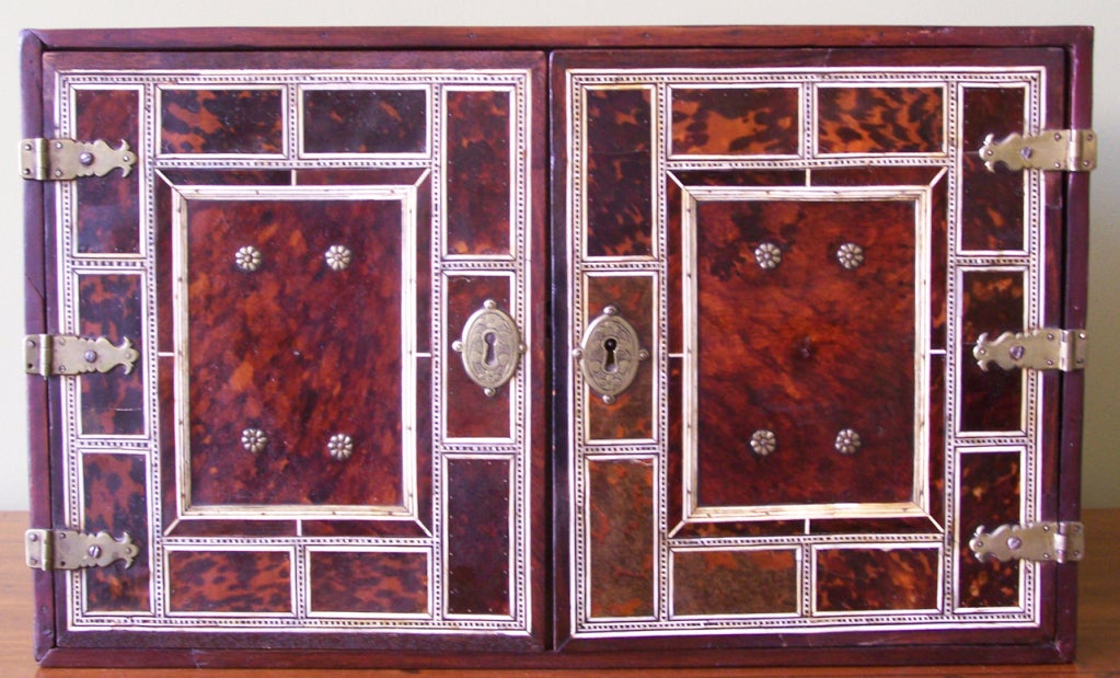 A truly beautiful and unique tortoise and ivory spice box. With many drawers, original pulls and gorgeous escutcheons, all set behind by a pair of magnificent doors, this piece cannot be missed. This piece is featured on page 23 of 