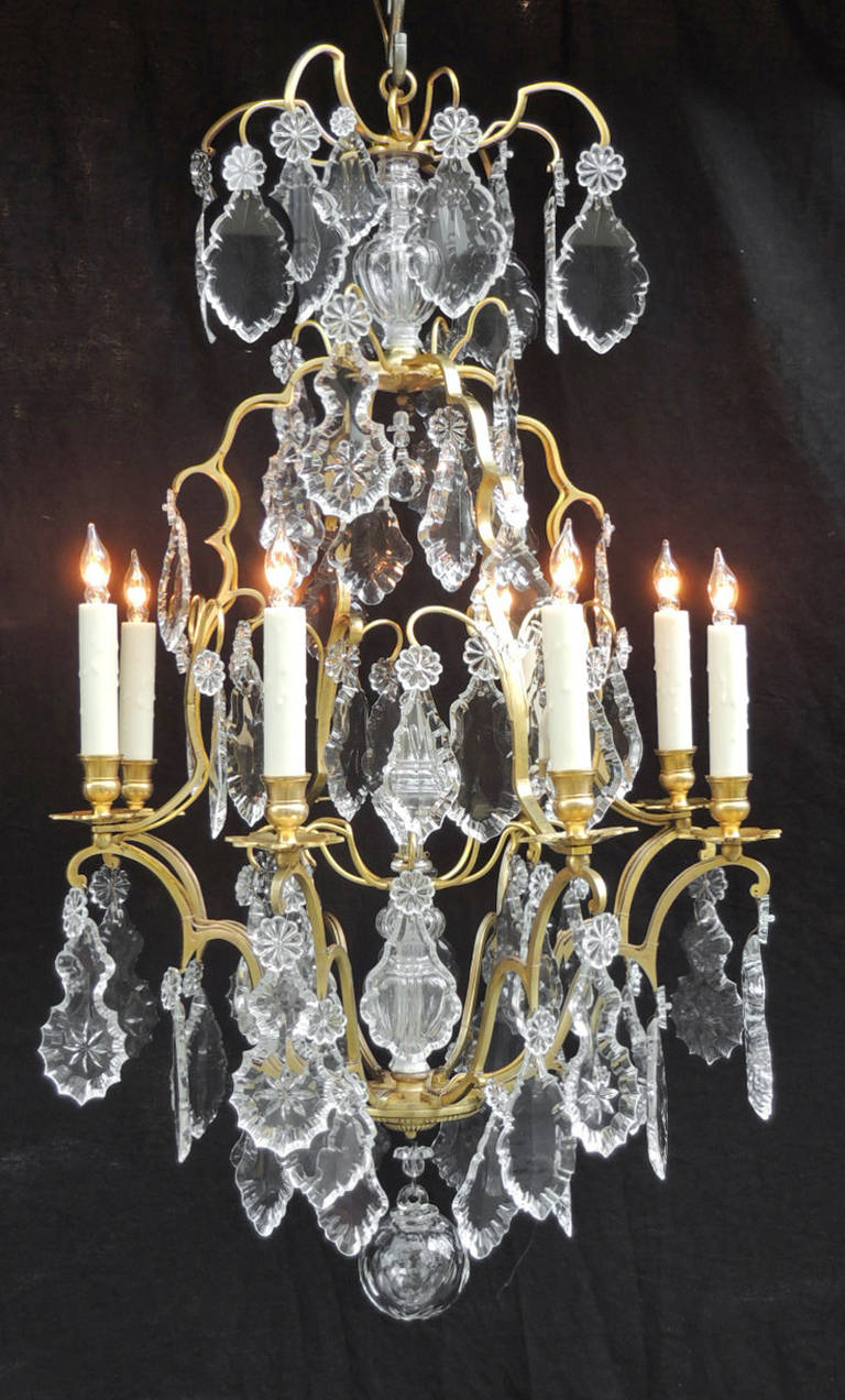This chandelier was made in 19th century France, circa 1840. The structure of this chandelier is done in a birdcage style with different size and style prisms. There is a central crystal finial that covers the middle section of the piece, as wells