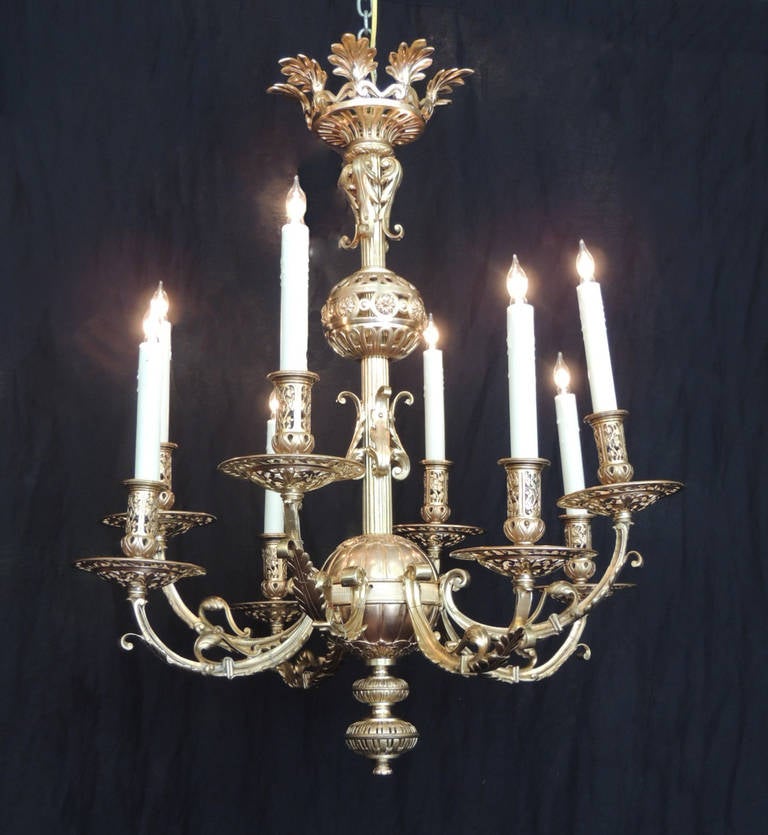 This chandelier was made in Russia during the late 19th century, circa 1870. It was made of cast bronze with bronze dore plate. The center pole features two bulbs on the center and bottom. The stem of the piece contains scrolling foliate details and