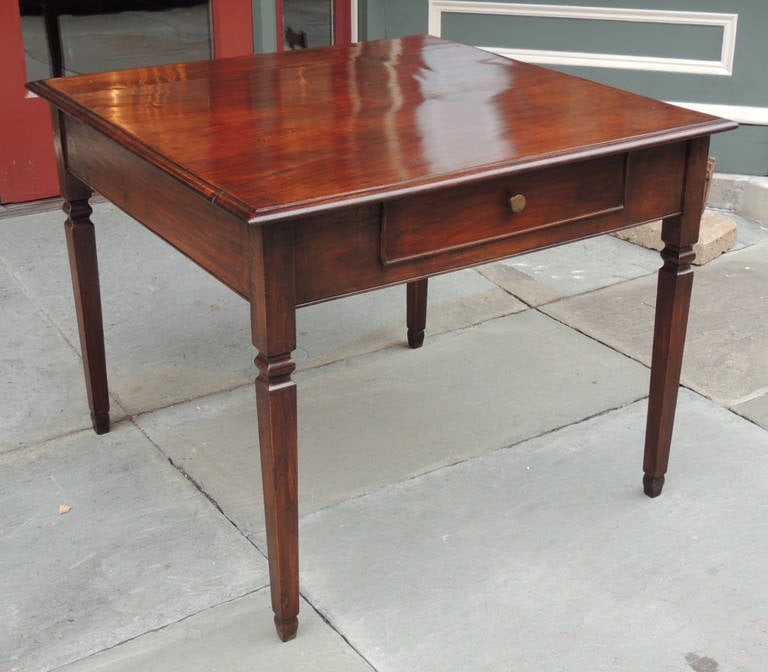 This table was made in Italy in the 18th century and was originally made to be a game table or breakfast table by its shape and size. This piece features one drawer with a simple pull and four square tapered legs. The legs have a carved detail below
