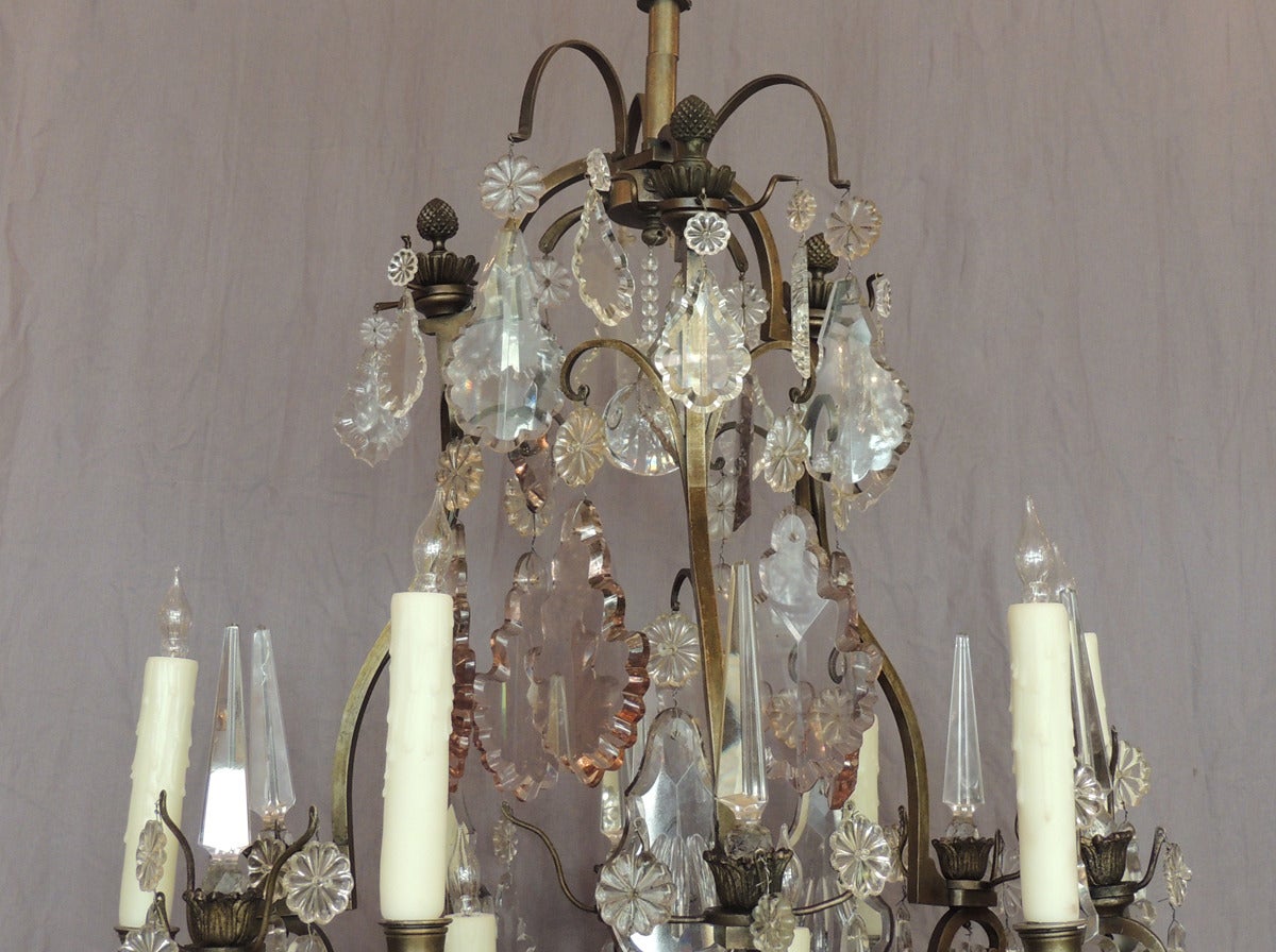 This beautiful French chandelier was made in the 1890's in France by Vian Henri. Henri was a famous Parisian bronze maker in the late 19th century. This is a Louis XIV birdcage style chandelier featuring clear, amber, and amethyst crystal.