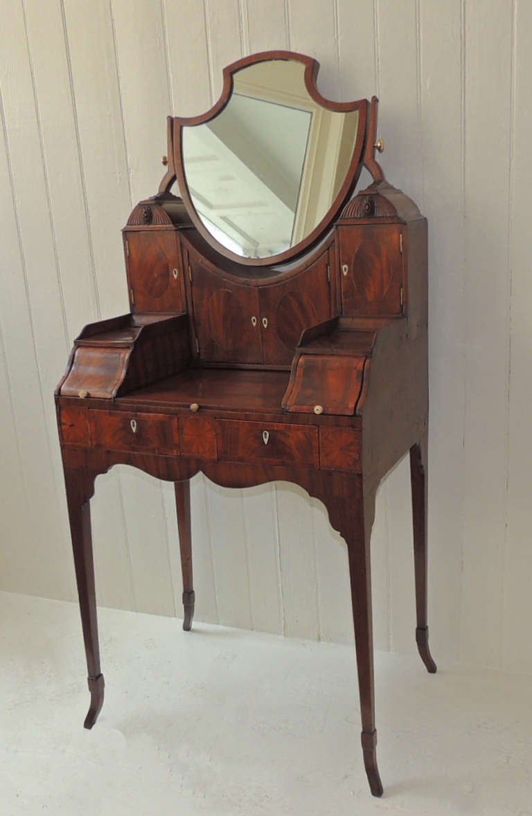 This beautiful ladies dressing table is made of solid mahogany with pine and dill secondary woods. The inlay veneer on this piece is satinwood and king wood, which gives it a wonderful shine to the exterior.