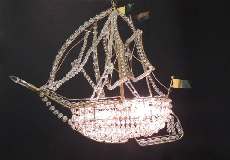 This set of three identical crystal ship chandeliers made in Italy during the first during the mid-20th century. They all feature three Tôle flags, one on the mainmast, one on the mizzenmast and one on the stern. The base is made of iron and is