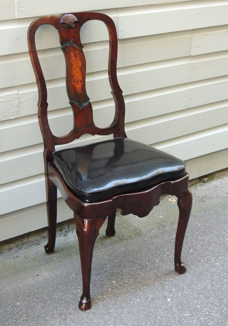 This set of English side chairs are created in the Dutch Queen Anne style. This set features a curved top rail with a central shell motif. The stiles are also curved and a simple carved detail toward the bottom near the shoe. The splat features