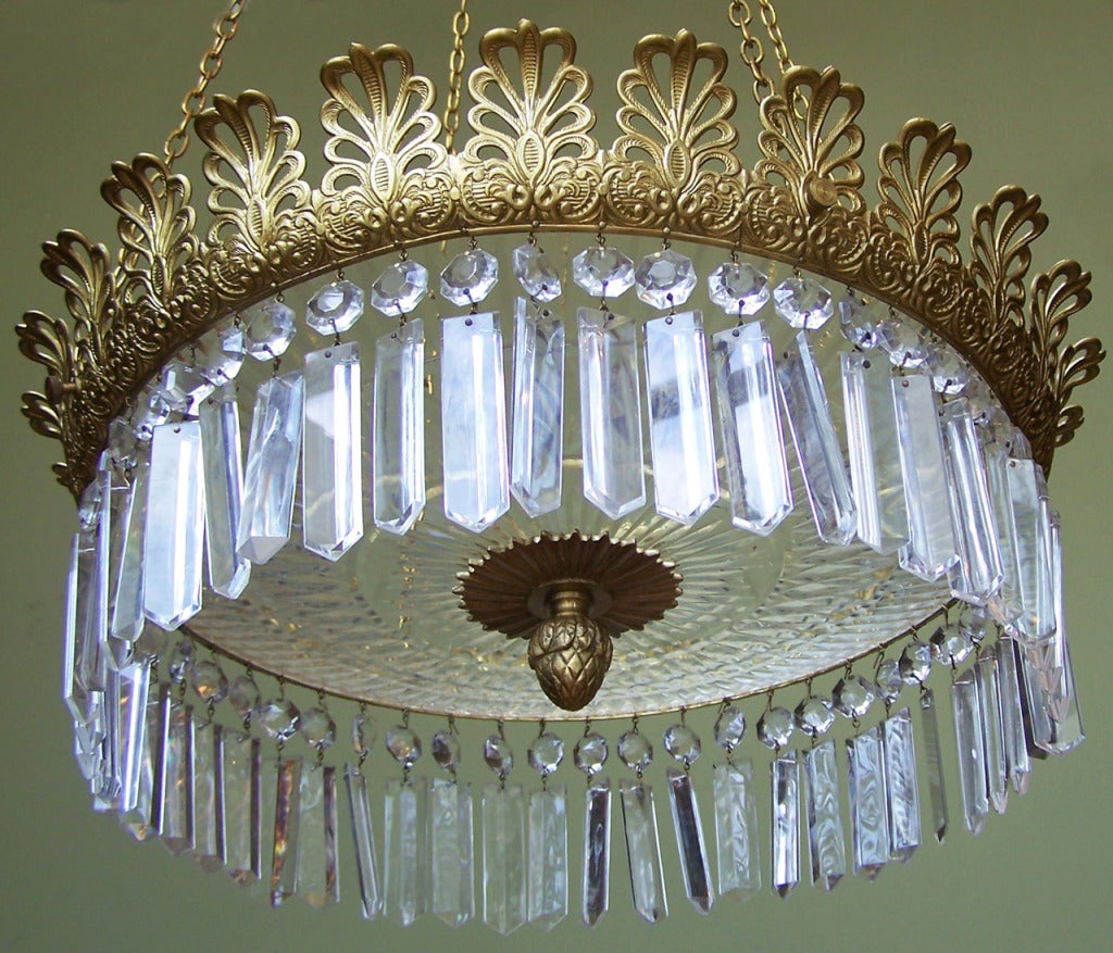 A truly beautiful Regency chandelier. Lovely brass and elegant crystal prisms with etched crystal bowl.