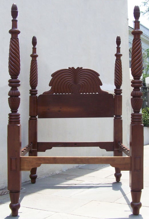 A rare British Colonial Jamaican bed. All mahogany, with abstracted West Indies pineapple motifs throughout, and exquisite twisted reed turnings on each of the posts.