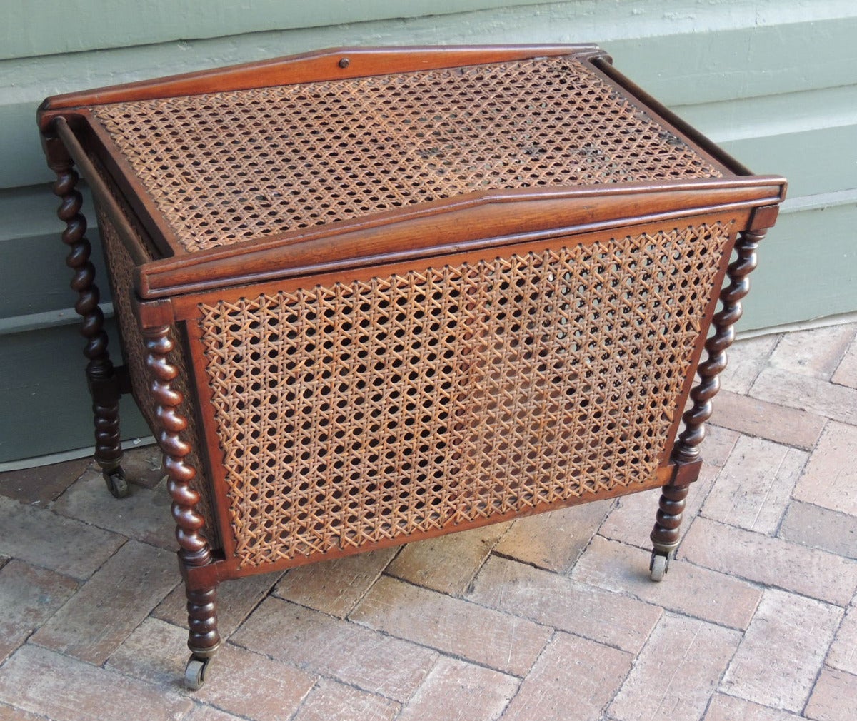 This piece was made in England during the 19th century, circa 1800. This piece was used to store sewing materials and fabric. The sewing box has both its original caning and casters. This piece features four mahogany barley twist sides.