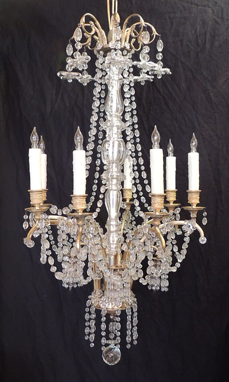 This chandelier was made in France during the first half of the 20th century, circa 1920, and features six hanging flowers above several crystal swags and a central crystal stem. There are four lights pointing downwards surrounded by crystal swags