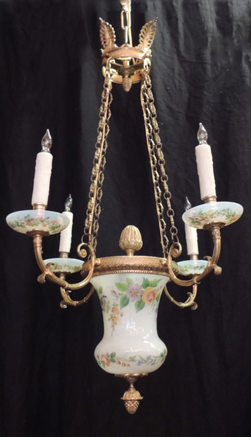 This chandelier was made in Russia in the first half of the 19th century, circa 1805. This piece features four anthemions on the top rim above four bronze chains attached to an urn-shaped, floral-painted opaline glass body with a top bronze finial.