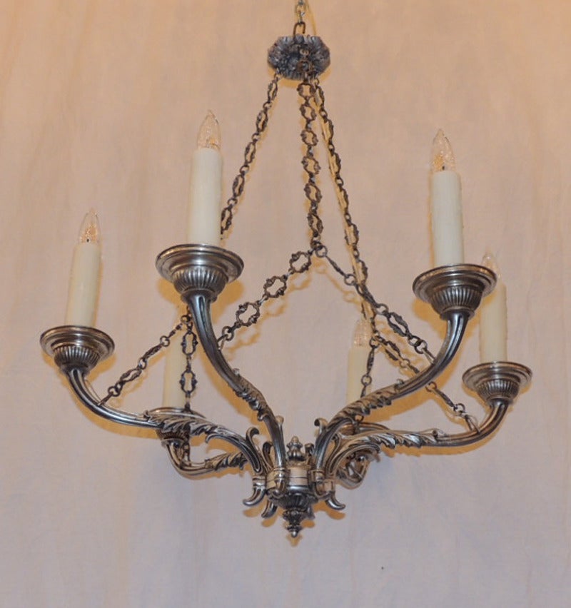 This elegant Italian Baroque chandelier was made during the late 18th century, circa 1780, featuring six arms with scroll and foliage designs suspended from the canopy by three chains.  Originally, the chandelier had candle prickets but has been
