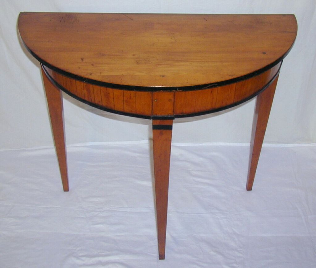 Three Tapered Leg Demilune Console with Pegged Walnut Top and Apron with Ebony Band on Apron and Legs.