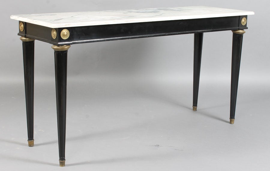 Double Beveled Arabescato Marble Top Extending over Bronze Mounted Ebonized Sofa Table with Recessed Apron Displaying Bronze Rondels on Corners Resting on Fluted Tapered Legs with Bronze Upper Leg Adornment ending in Bronze Cased Feet.
