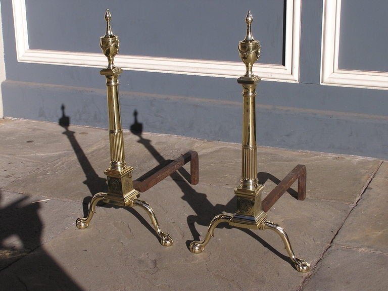Pair of American brass andirons with urn swag finials, fluted column on squared chased plinth, and terminating on spur leg with ball and claw feet. Philadelphia.   Dealers please call for trade price.