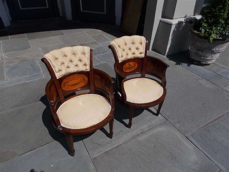 Pair of English mahogany arm chairs with satinwood oval urn inlays, bell flowers with ribbons, upholstered seat and back, terminating on inlayed tapered spayed legs.  Circa 1850.