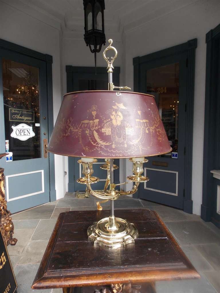 French brass three light bouillote lamp with floral motif and original telescopic  tole shade.  Originally candle powered. Lamp has been electrified. Early 19th Century.