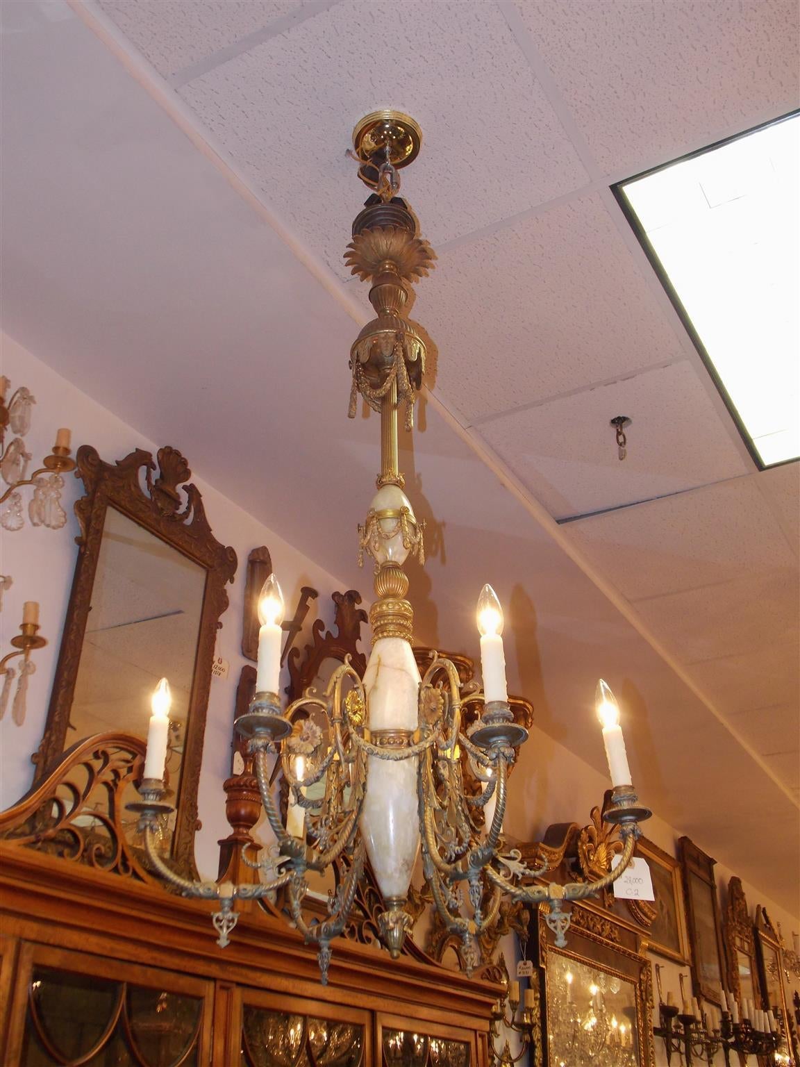 Italian gilt bronze and onyx six-light chandelier with scrolled floral arms, original keys, decorative medallion and tassel motif and terminating on fluted floral finial. Chandelier was original gas and has been converted, Mid-19th century.