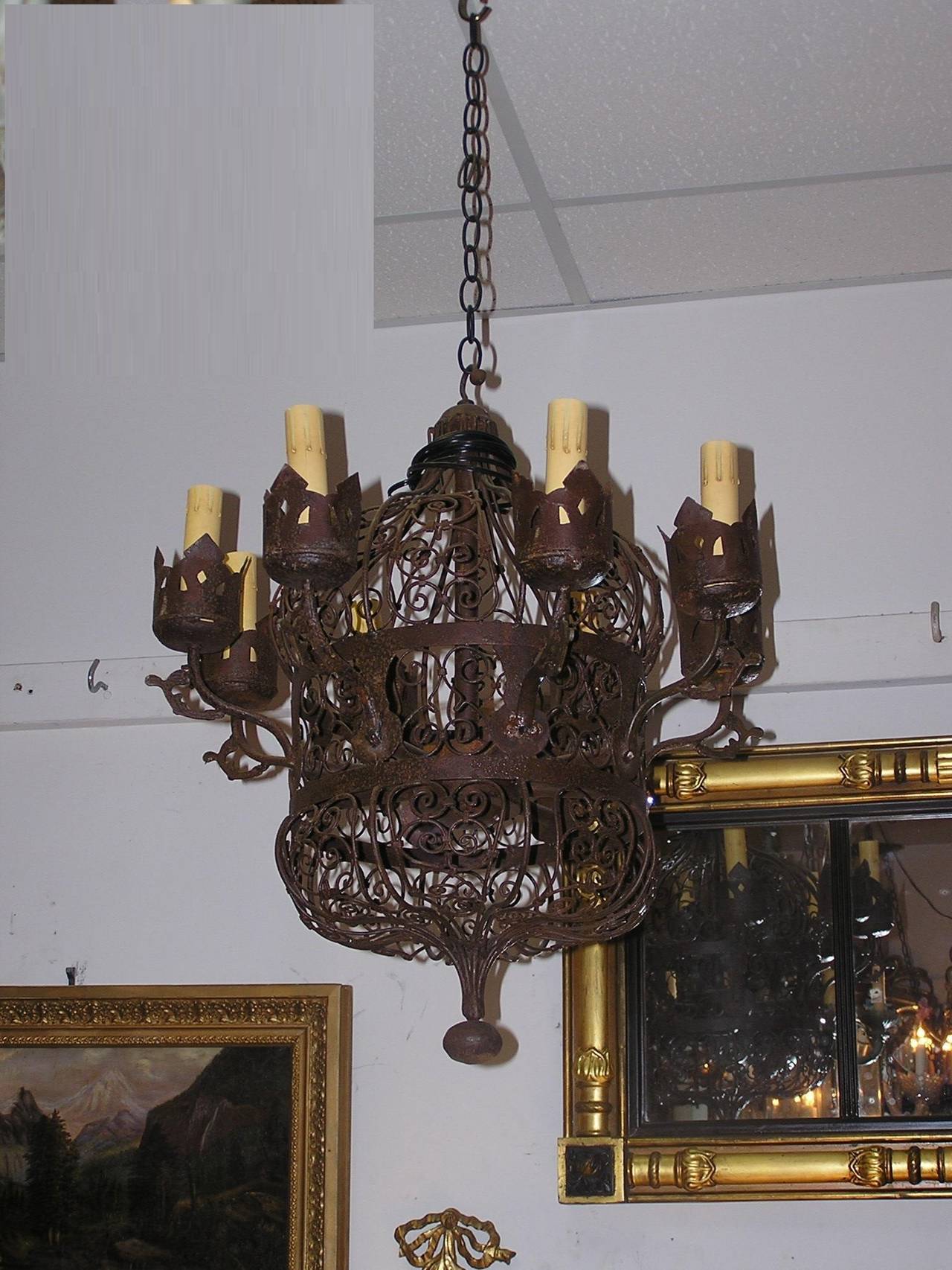 American wrought iron eight light chandelier with decorative scrolled wire work, pierced decorative bobaches, and terminating on centered tapered iron ball finial.  Mid 19th Century.  Chandelier was originally gas and has been electrified.
