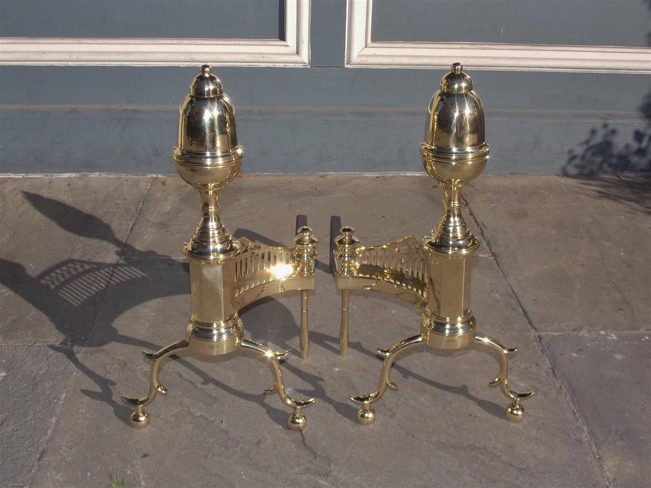 Pair of American acorn top andirons with turned faceted plinths, brass pierced galleries, finial log stops, and terminating on double spur legs with ball feet. Philadelphia, Circa 1800