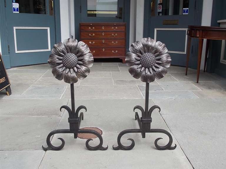 Pair of American wrought iron sunflower medallion andirons with floral plinths and terminating on scrolled legs.  20th Century