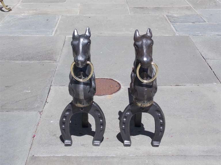 Pair of American cast iron and brass horse andirons terminating on horse shoe motif legs.  Mid 19th Century