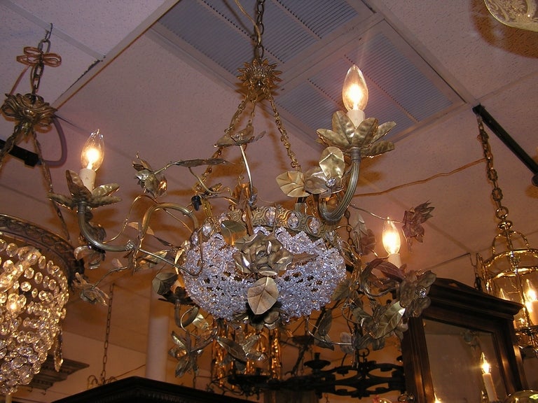 Italian gilt bronze and crystal four light chandelier with lower centered intertwined crystal basket, scrolled arms, and floral motif. Originally candle powered. Dealers please call for trade price. 