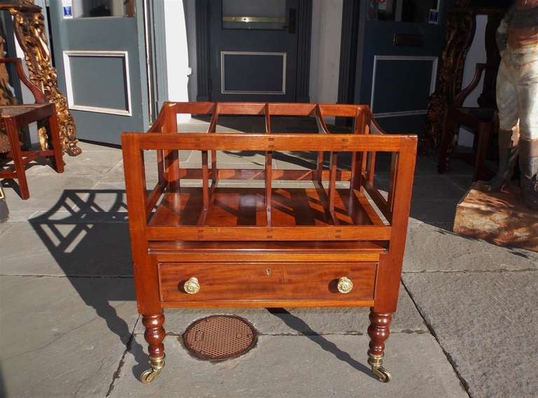 A rare large English Regency period one drawer mahogany Canterbury with four slatted divisions, terminating on turned bulbous legs with original period casters.  Early 19th Century.