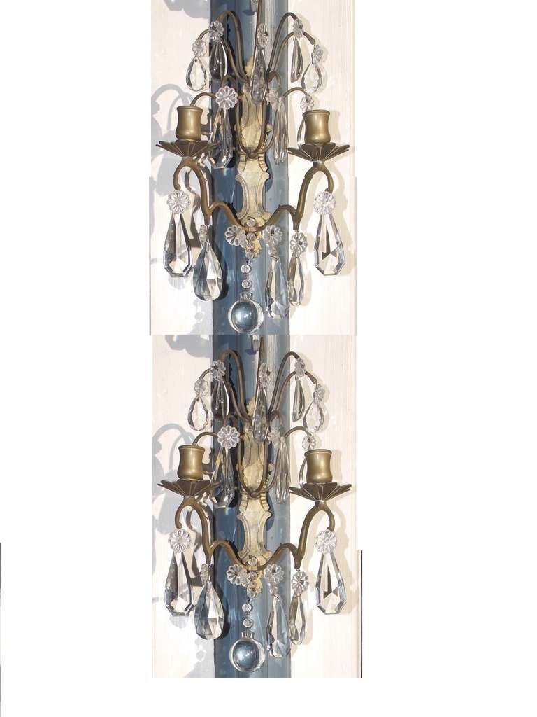 Pair of French gilt bronze and crystal two arm wall sconces.  Sconces are candle powered and can be electrified if desired.  Early 19th century.