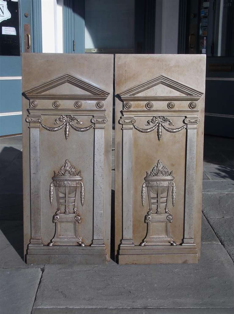 Pair of English polished steel fire backs with paladin tops, floral ribbon swags, ionic columns, centered decorative flaming urn with paw feet resting on squared plinth with hoof feet.  Late 18th Century
