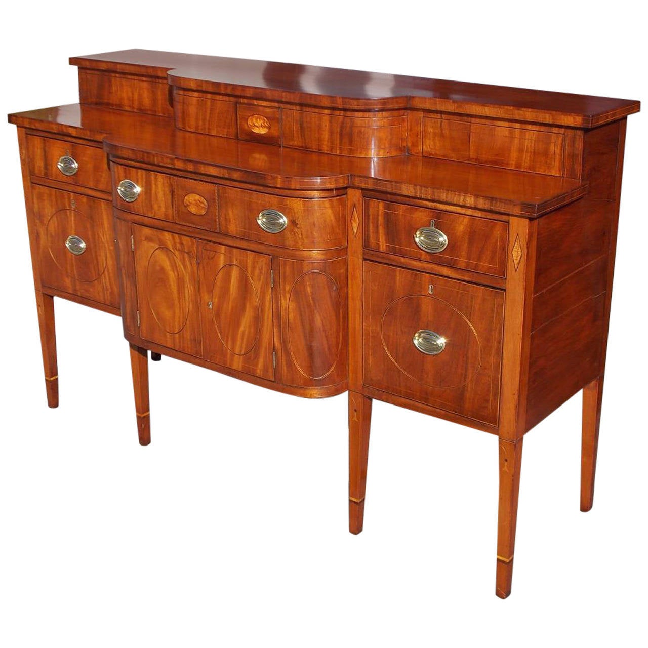 Charleston mahogany bow front stage top sideboard with birch oval and diamond inlays, bell-flowers, rosewood dots, cherry sides, and six drawers with lower cabinet terminating on cuffed tapered legs, Circa 1800.