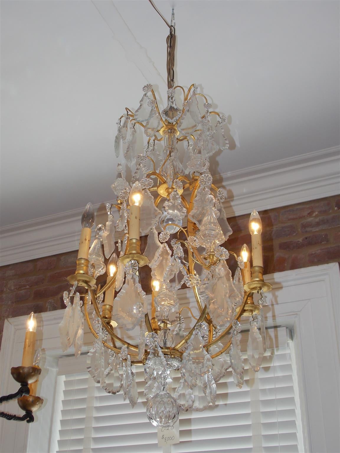 French gilt bronze and crystal six light chandelier with faceted crystal spheres, interior fluted column, and terminating with lower cut crystal ball.  Originally candle powered and has been electrified.  Mid 19th Century