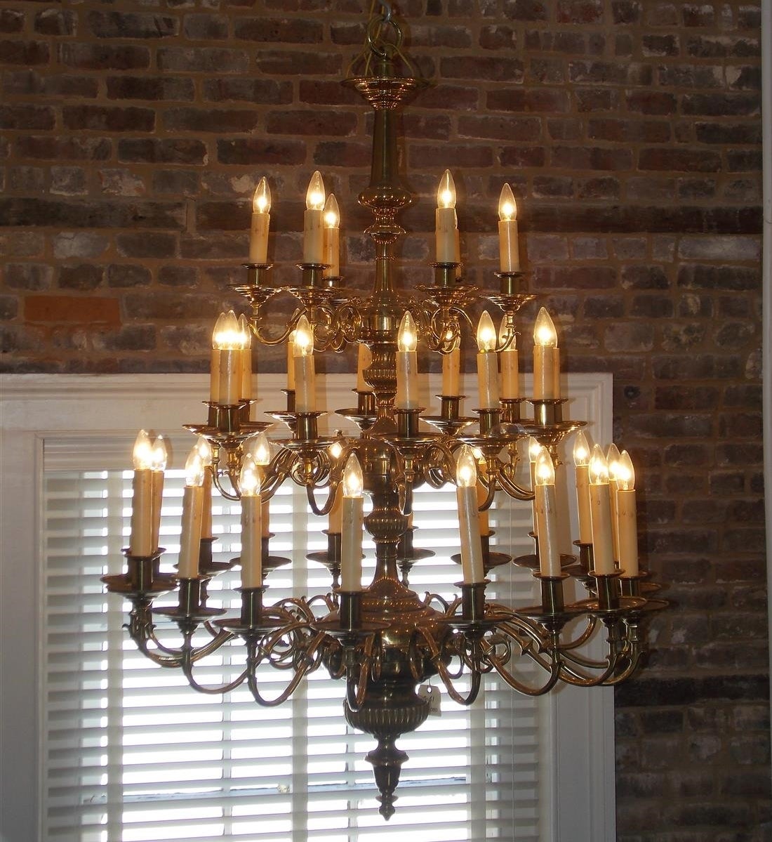 American brass monumental three-tier thirty-five light chandelier with centered bulbous turned ribbed column, scrolled spurred arms and terminating with a large decorative finial. Originally candle powered and has been electrified, Mid-19th century.