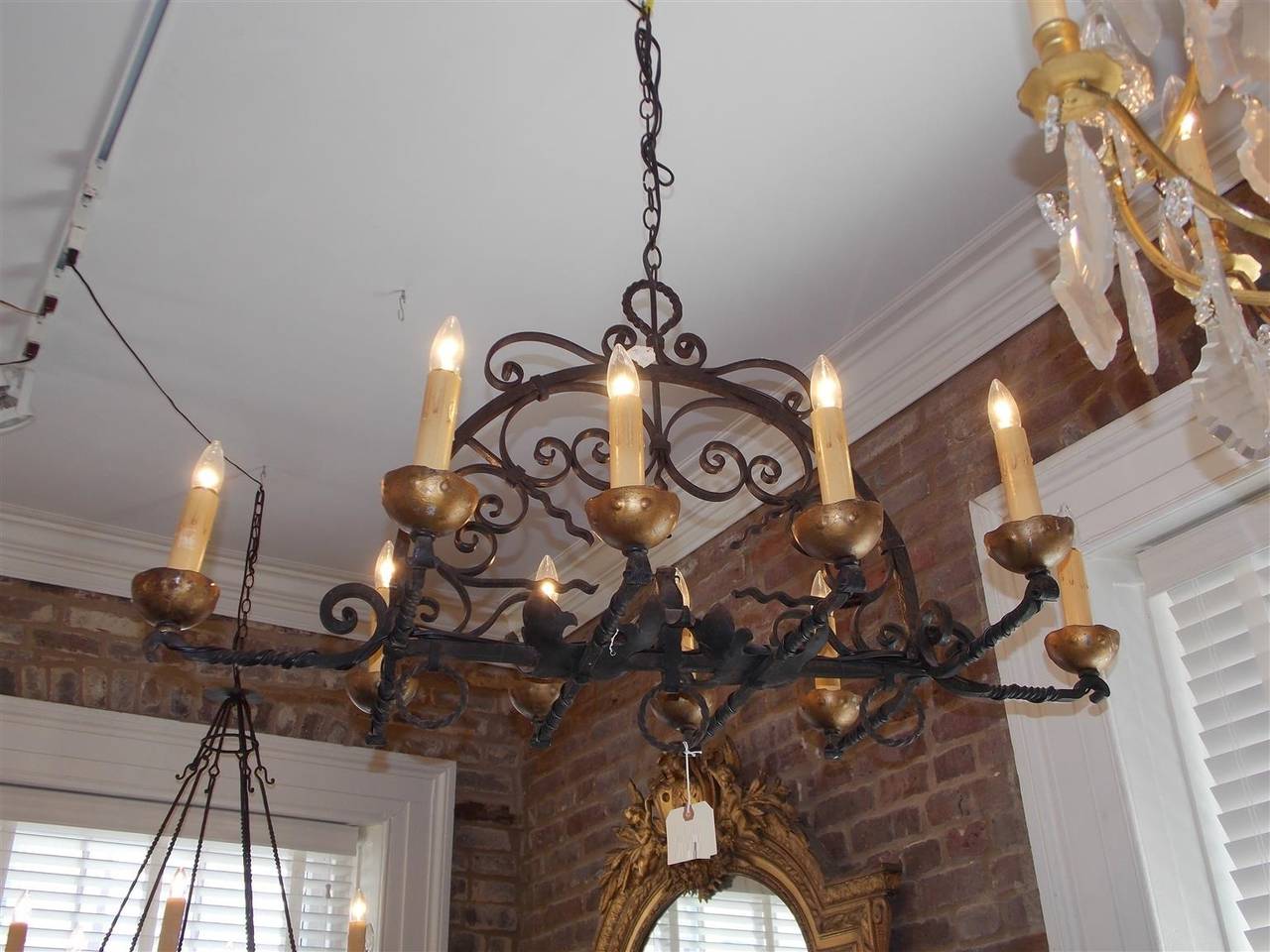French wrought iron and gilt elongated chandelier with decorative scroll work and curled twisted arms. Originally candle powered and has been electrified.
 Mid 19th Century