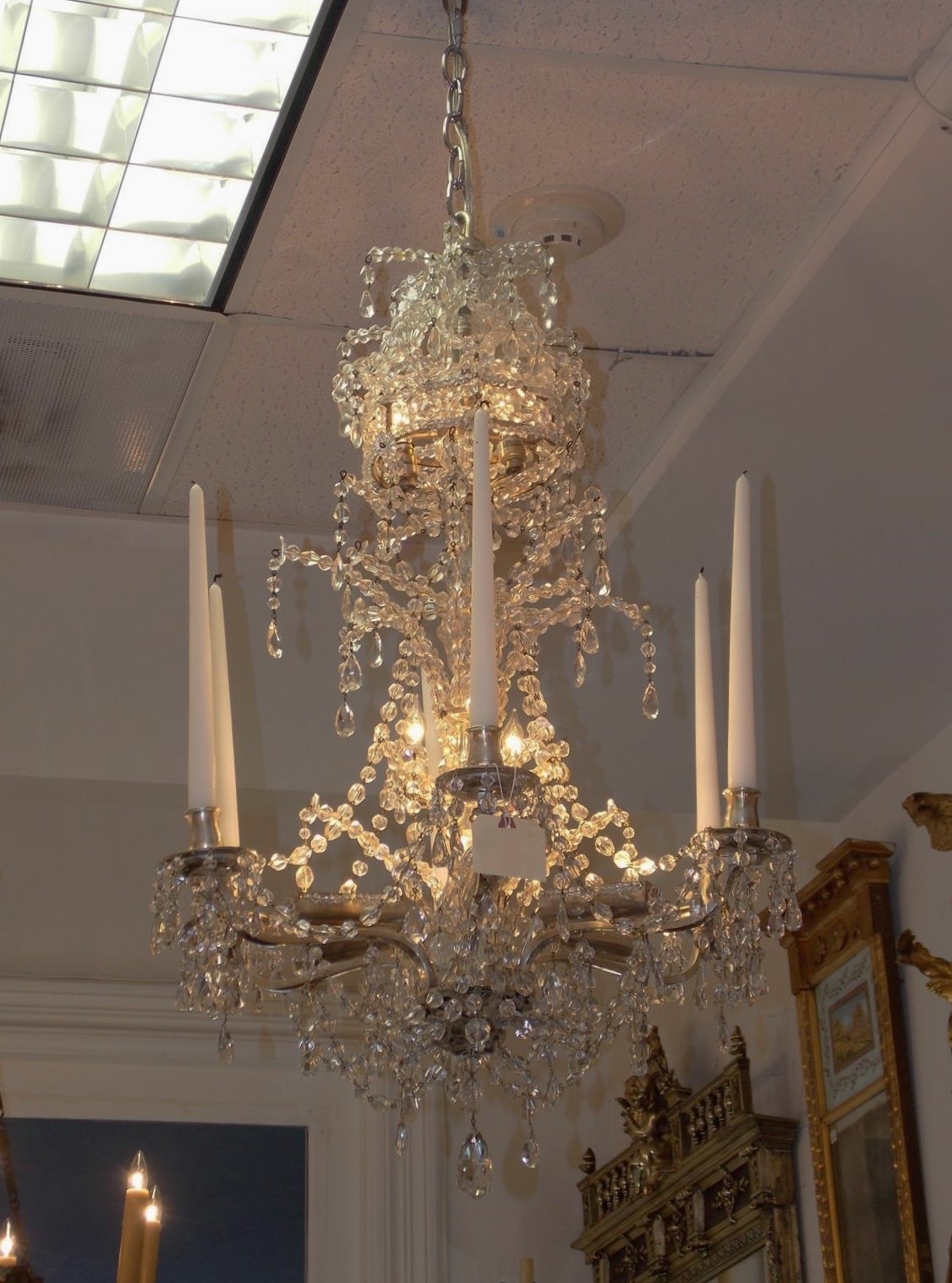 French  silver gilt nickel and bronze crystal chandelier with six candle arms, electrified crystal central column, six fitted interior lights, and intertwined crystal bead work. Late 18th century. Candle arms can be electrified at no additional cost