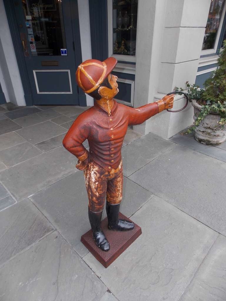 English painted cast iron lawn jockey standing on squared plinth. Late 19th Century.