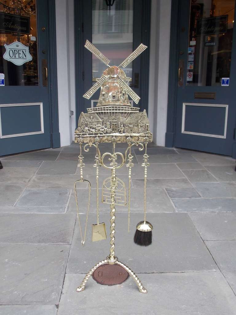 Dutch brass windmill fire tool set on twisted shaft with stylized tripod base.  Set consist of tongs, shovel, poker, trivet, and brush.  Early 20th Century