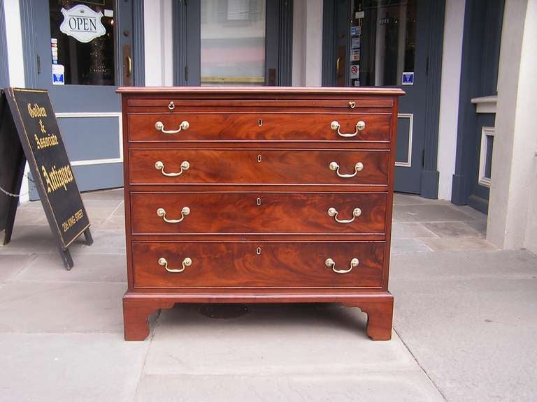 English mahogany graduated four drawer bachelors chest with original pull out brushing slide, brasses, and bracket feet. All original.  Dealers please call for trade price