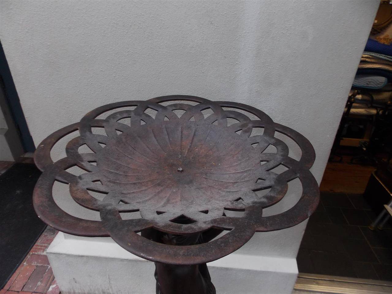 English cast iron decorative figural pedestal with intertwined circular bowl,  standing on a triangular bell flower and acanthus lions paw base.  Early 19th Century.