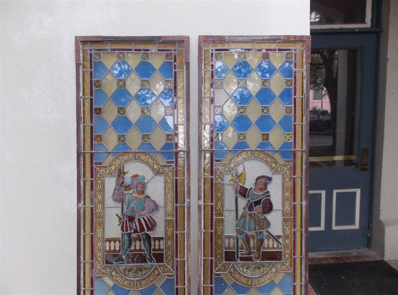 Pair of English stained glass panels with centered Royalty guard figures secured with lead and surrounded by wood frames.  Mid 19th Century.