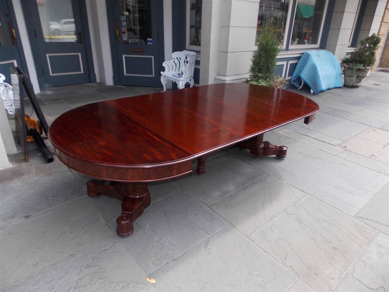 American Classical mahogany expandable round to oval dining room table with a turned bulbous centered pedestal on original brass casters. Boston, Early 19th Century Table has three leaves at 18.5