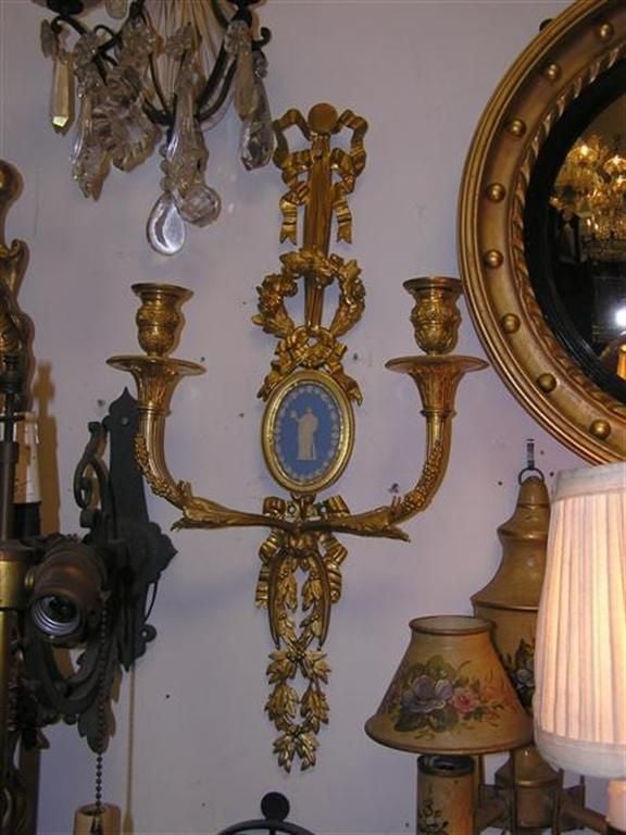 Pair of French gilt bronze floral ribbon two arm wall sconces with decorative figural and graduated bell flower oval jasperware, Late 18th Century. Pair are candle powered and can be electrified if desired at no additional cost.