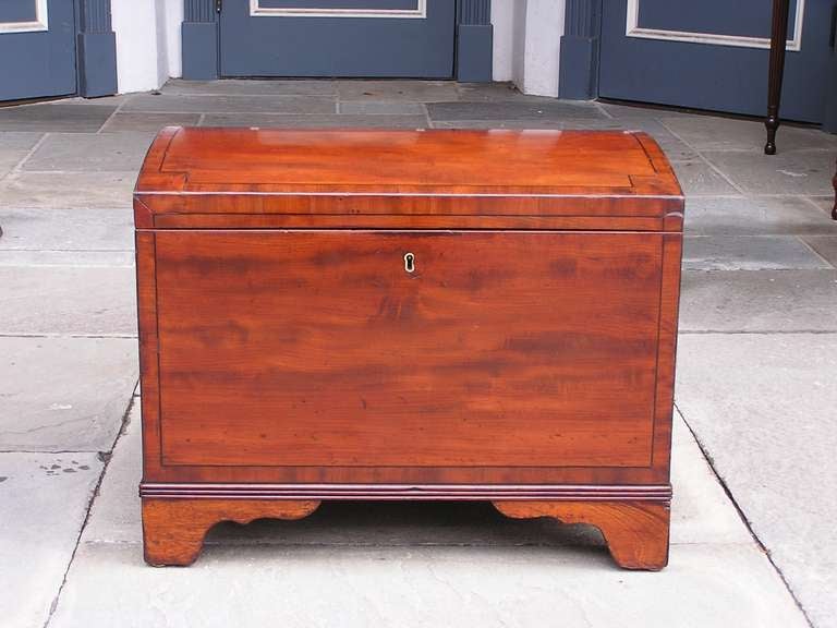 American mahogany gentleman's traveling chest with bowed top, cross banded mahogany, ebony string inlay, fitted interior, and original brass handles and feet.  Early 19th Century