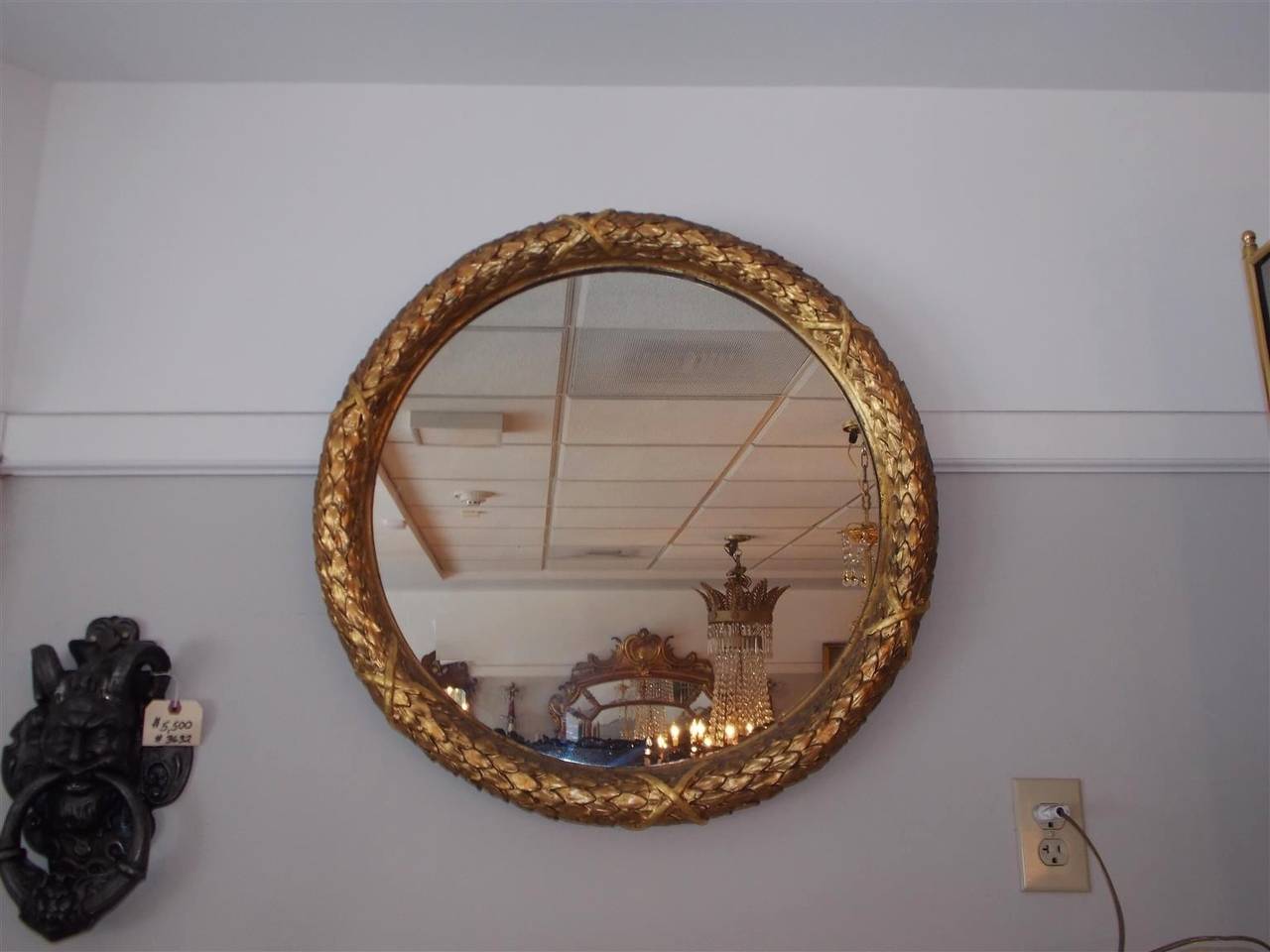 French gilt carved wood circular mirror with intertwined decorative floral and cross hatching motif. Mirror retains the original glass. Early 19th century.