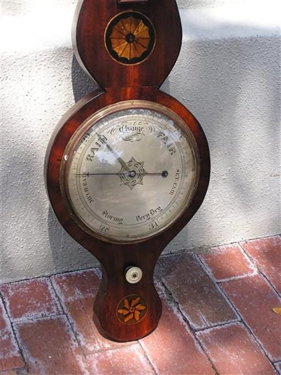 English mahogany barometer with satinwood pinwheel, patera, and original ivory knob. 
