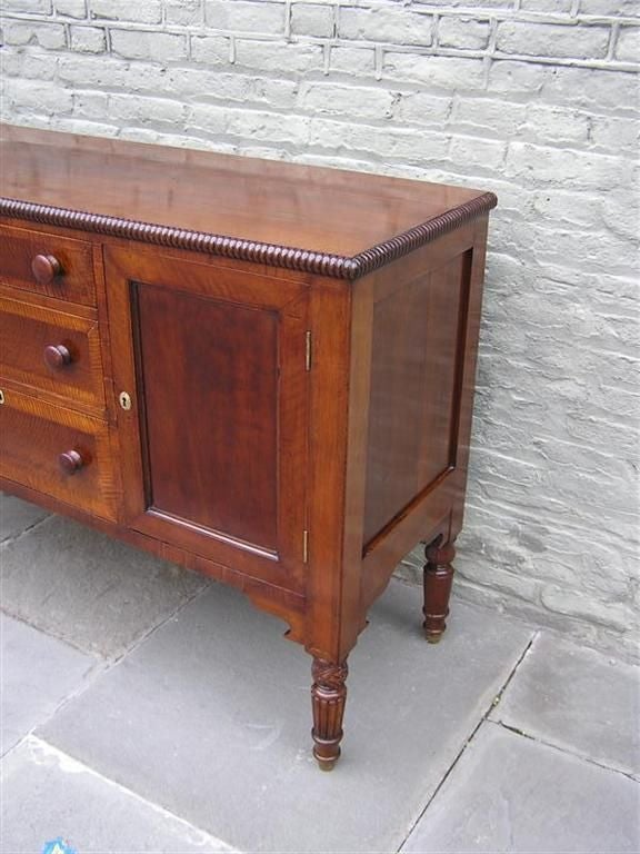 American Cherry, Walnut, and Tiger maple three drawer sideboard / server with carved molded edge, carved acanthus leaf, and reeded legs. Kentucky