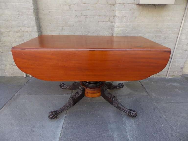 American mahogany one drawer rectangular drop leaf breakfast table with turned carved bulbous pedestal, terminating on carved foliage legs on lions paw feet, with original brass casters. Philadelphia. Dealers please call for trade price.