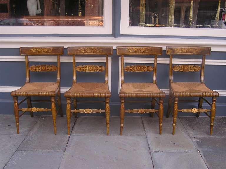 Set of four American Fancy chairs with hand stenciled floral motif, original rush seats, and terminating on turned bulbous and saber legs. Early 19th Century.